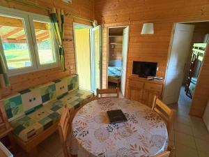ein Esszimmer mit einem Tisch, auf dem ein Laptop steht in der Unterkunft Chalet Campanules 37 - Nature, Randonnée & Famille - FR-1-583-471 in Mélisey