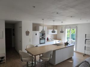 a kitchen with a wooden table and white cabinets at Le Frais Jus in Fréjus
