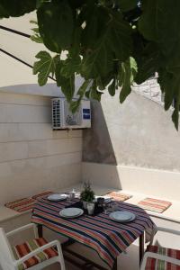 a table with plates on it on a patio at Fig Tree in Povlja