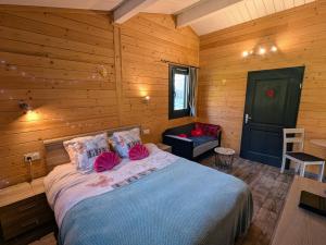ein Schlafzimmer mit einem Bett in einem Holzzimmer in der Unterkunft Chalet détente avec Spa et animaux admis près de Plombières-les-Bains - FR-1-583-498 in La Vaivre