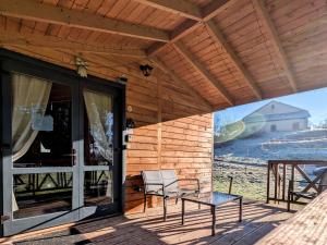 eine Veranda eines Hauses mit zwei Stühlen und einem Fenster in der Unterkunft Chalet détente avec Spa et animaux admis près de Plombières-les-Bains - FR-1-583-498 in La Vaivre