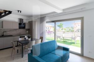 a living room with a blue couch and a table at Homiday - Case Vacanza Elea in Pineto