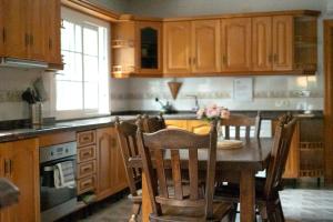 a kitchen with a wooden table with chairs and a dining room at Villa Mis 5 Amores con piscina in Benidorm