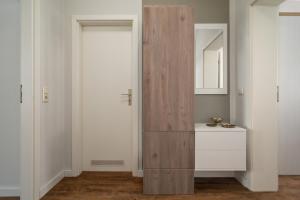 ヴァーレンにあるApartment "Hafenkino" am Stadthafen Waren Müritzの部屋にある鏡付きの背の高いキャビネット +17枚の写真