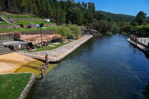 a river with people standing in the water at Casa VazPeralta in Castanheira de Pêra