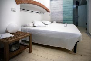 Un dormitorio con una gran cama blanca y una mesa en La Casa di Elisa, en Camogli