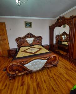 a bedroom with a wooden bed and a large mirror at Daily rental house in Gori