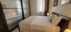 a bedroom with a bed with white sheets and a window at Alloggio Turistico Tedeschi in Santa Maria delle Mole +3 photos