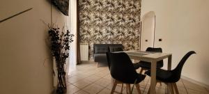 a dining room with a table and black chairs at Alloggio Turistico Tedeschi in Santa Maria delle Mole