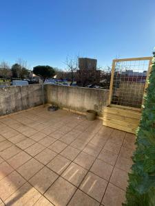 eine Terrasse mit einer Holztür und einem Zaun in der Unterkunft Gîte les Herbiers in Les Herbiers