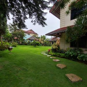 a yard with green grass and a building at Villa Kusuma 14, Large Garden & Karaoke in Batu City in Batu