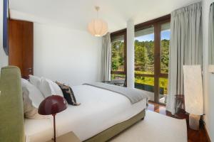 a bedroom with a bed and a large window at WHome Estoril Design Villa Garden & Comfort in Estoril