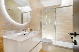 a bathroom with a sink and a toilet and a mirror at WHome Estoril Design Villa Garden & Comfort in Estoril +28 photos