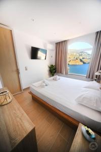 a bedroom with a large bed with a large window at Blue Horizon Apartment in Kalymnos