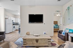 a living room with a couch and a tv on a wall at Beach Ballin in Galveston