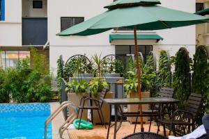 a table and chairs with an umbrella next to a pool at Cozy homes in Rongai