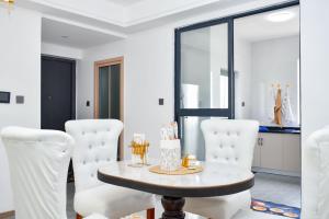 a dining room with a table and white chairs at Cozy homes in Rongai
