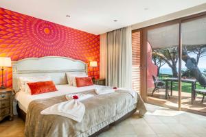 a bedroom with a large bed with a red wall at Boutique Hotel Vivenda Miranda in Lagos