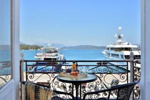 ポロスにあるPoros Moodのテーブルと水に浮かぶ2隻のボートがあるバルコニー