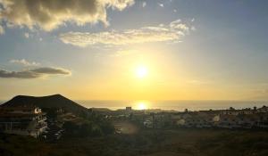 a view of the sun setting over a city at Stone Villa in Chayofa