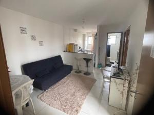 ein Wohnzimmer mit einer blauen Couch und einer Küche in der Unterkunft Apartamento Completo Mobiliado in Caruaru
