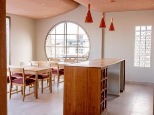 a dining room with a table and chairs and a window at Joy Tower by FMA Coliving in Salta