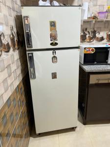a white refrigerator in a kitchen with magnets on it at شقة خلف فندق الإليزي in Hurghada