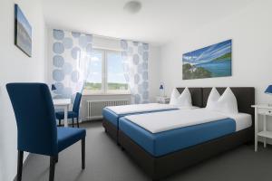 a bedroom with a blue bed and a blue chair at Frühstückspension Zur Krone in Bad Endbach