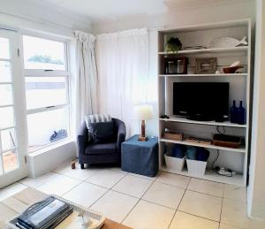 a living room with a tv and a chair at Mclaren Self Catering in Gansbaai