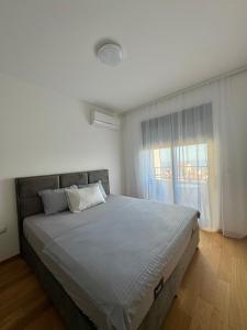 ベチチにあるLalur apartment Bečićiの大きなベッドと窓のある寝室
