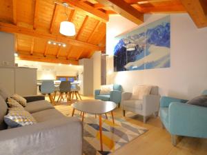 Una sala de estar con sofás y sillas y una mesa. en Charmant appartement 3 pièces avec parking et wifi à Saint-Martin-de-Belleville - FR-1-452-351, en Saint-Martin-de-Belleville