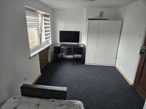 an empty room with a desk and a television at Apartament Ogrodowa in Biała Podlaska