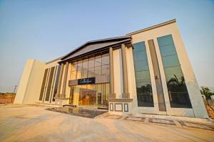 a large building with glass windows on a street at Palette - The Mark Club & Resorts in Durg +18 photos