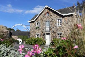 une maison en pierre avec une roue ferris en arrière-plan dans l'établissement Hotel Aux Ecuries De La Reine, à La Gleize