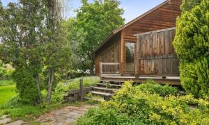 a wooden cabin with a porch and stairs in a garden at Zoo Town House with Sauna in Missoula