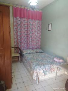 a small bedroom with a bed and a window at Quarto em casa compartilhada in Manaus