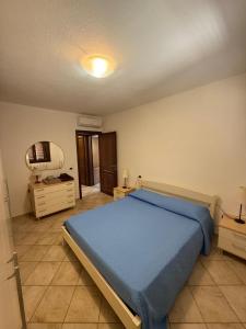 a bedroom with a blue bed and a mirror at Casa Rita in Olbia