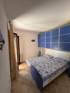 a bedroom with a bed with a blue headboard at Casa Rita in Olbia