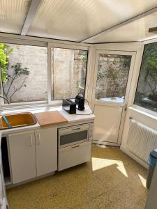 クルブヴォアにあるLarge two-room apartment with gardenの窓2つとカウンタートップ付きのキッチン +7枚の写真