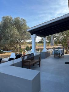 acovered patio with benches and a table and chairs at Can Mateu 1924 in Sant Francesc Xavier