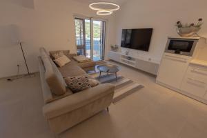 un soggiorno con un divano e una TV di Apartment JARO a Stomorska