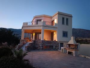 a large white house with a staircase in front of it at Ethirenia in Karistos