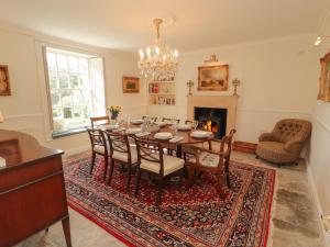 a dining room with a table and chairs and a fireplace at Garsdale Foot in Sedbergh