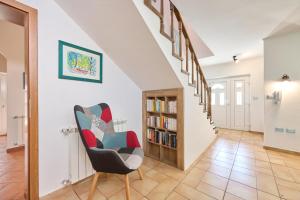 a hallway with a chair and a book shelf at Casa di Oliva in Brtonigla