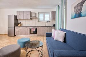 a living room with a blue couch and a kitchen at Casa di Oliva in Brtonigla