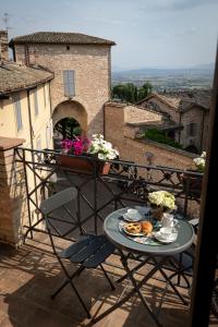 a table and chairs sitting on a balcony at Santa Chiara Apartment in Assisi