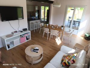 Una sala de estar con un sofá y una mesa con televisión. en Belle de Mai, en Mézos