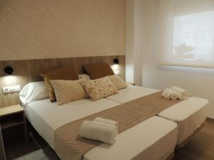 una camera da letto con un letto grande con asciugamani sopra di ESTORIL Vista Mar Premium Special a Benicàssim Altre 54 foto