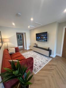 a living room with a red couch and a flat screen tv at Fisherman's Cottage, 3 Bedrooms, Wild Atlantic Way, Free Parking, Bike Hire in Killybegs