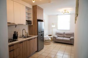 a kitchen with a stainless steel refrigerator and a couch at Departamento Palo Verde in Hermosillo